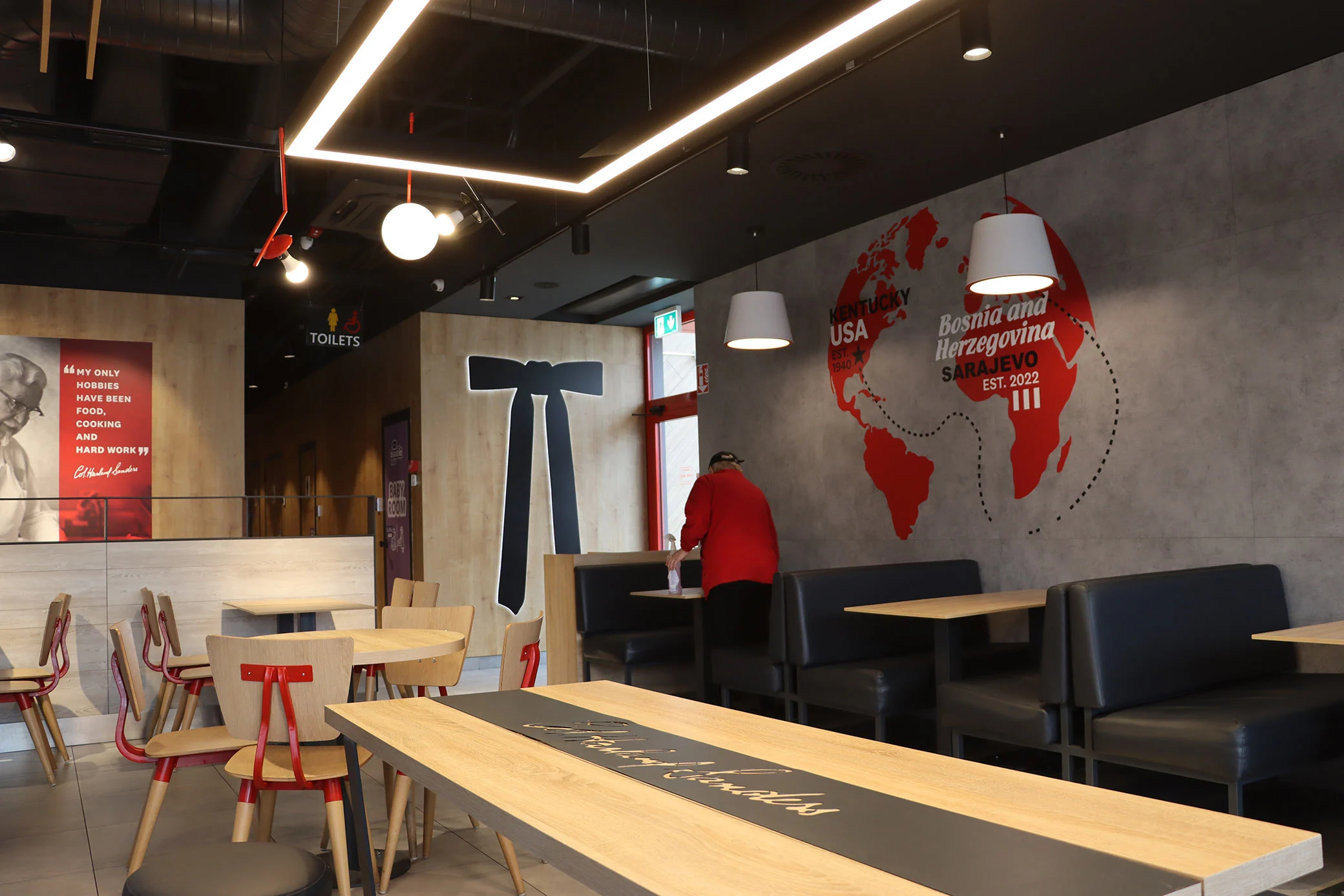 enterijer kfc restorana sa modernim sjedećim prostorom i zidnom mapom svijeta