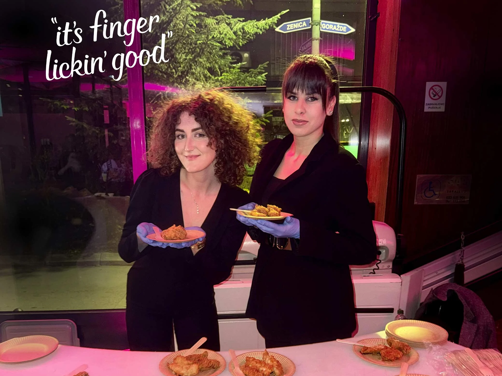 kfc zaposlenice predstavljaju hranu uz slogan “it’s finger lickin’ good” u restoranu
