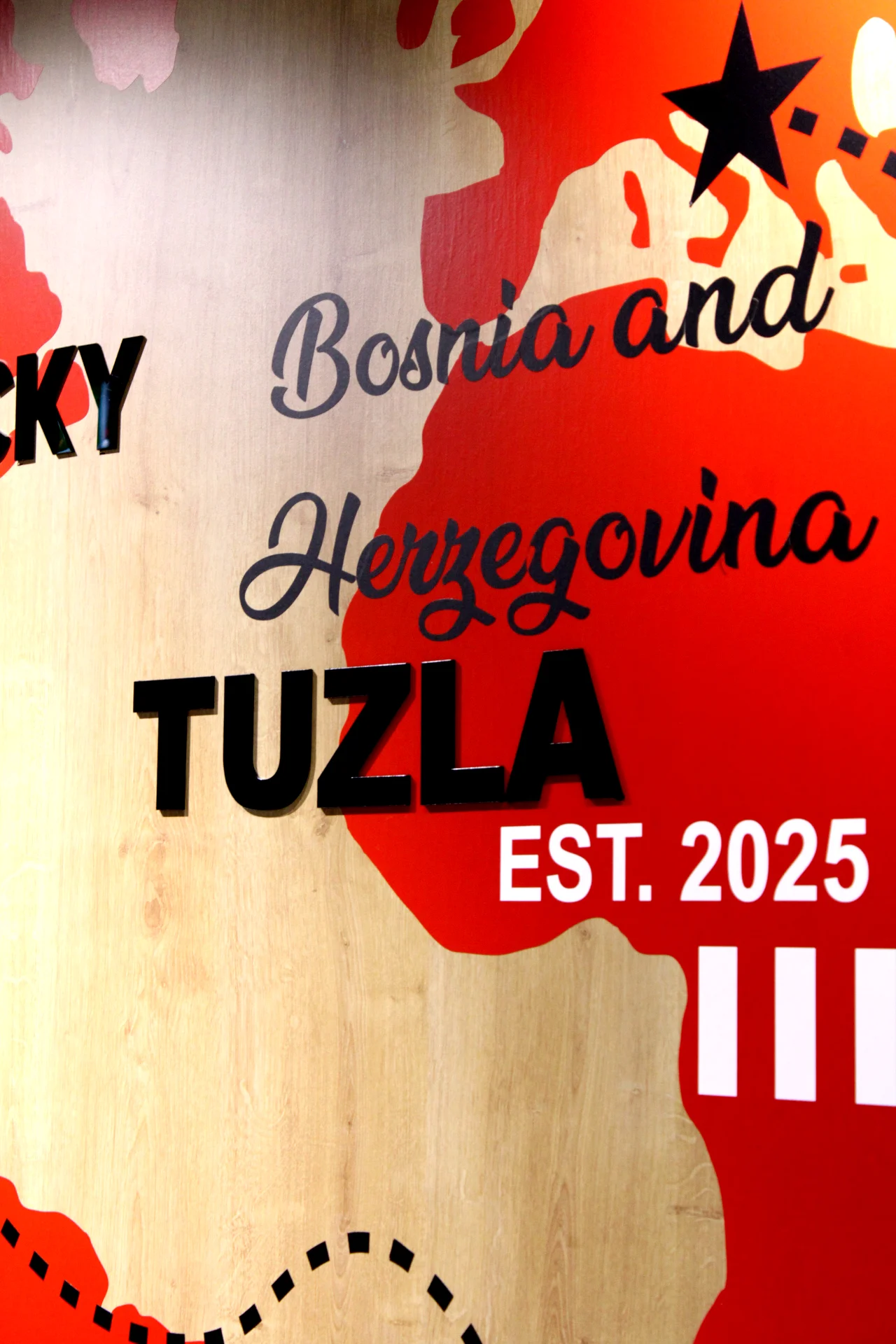 stylized poster with red map shapes and bold black text reading tuzla, bosnia and herzegovina, est. 2025.